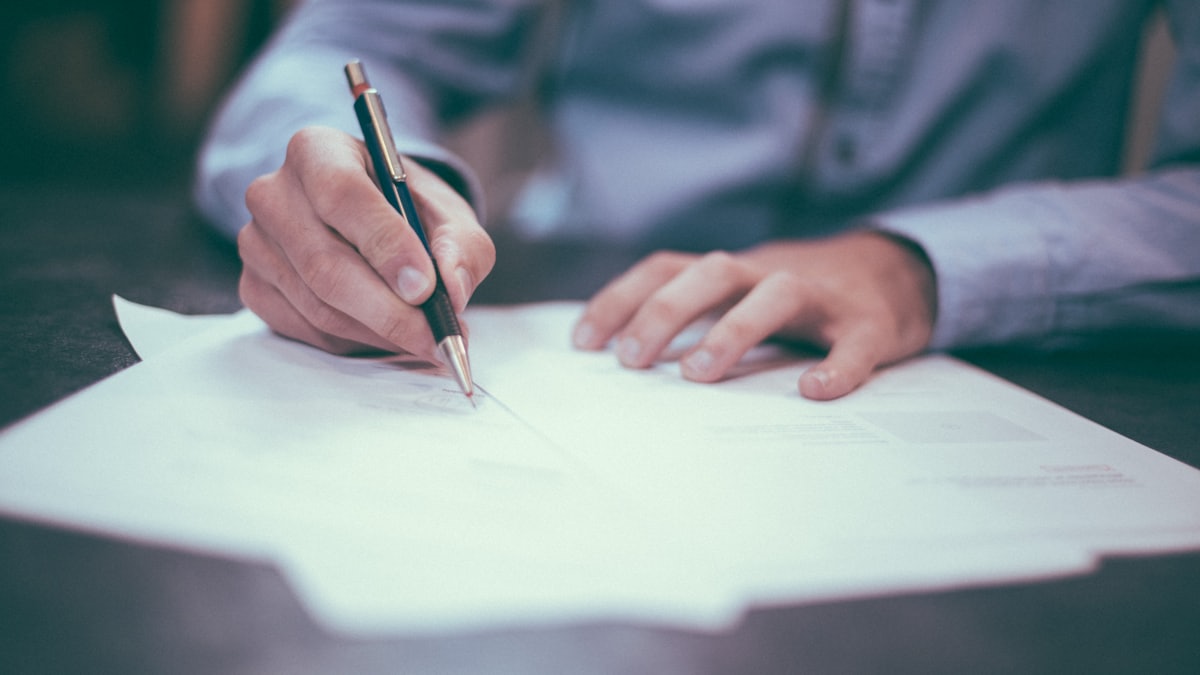 Close-up of hands reviewing documents at a kitchen table
